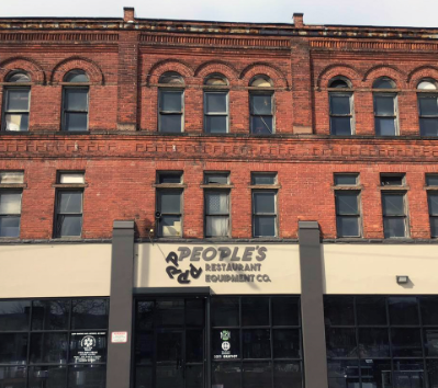 Brick building exterior with logo for People’s Restaurant Equipment 